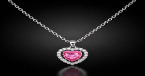 Aura Amore heart halo necklace featuring a pink crystal heart pendant surrounded by sparkling stones on a silver chain.