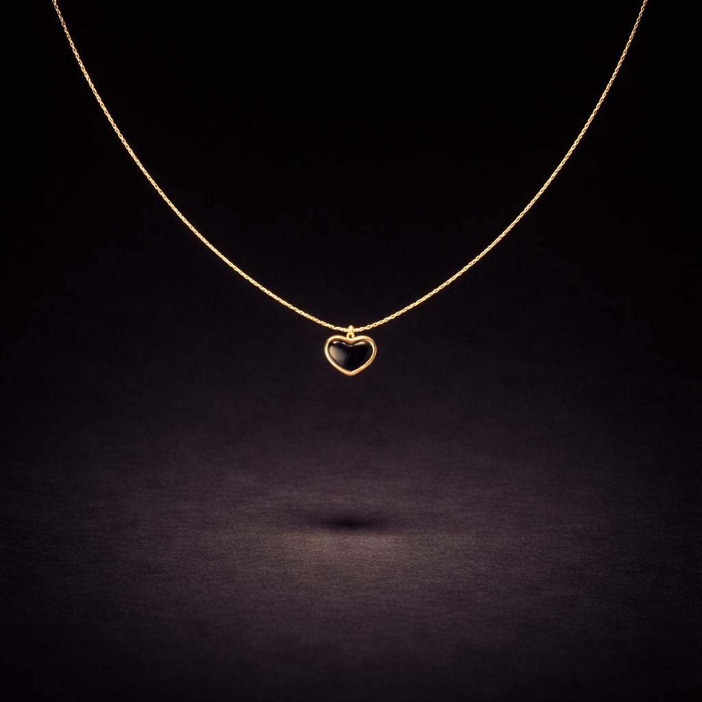 Gold necklace with black heart-shaped pendant on delicate chain