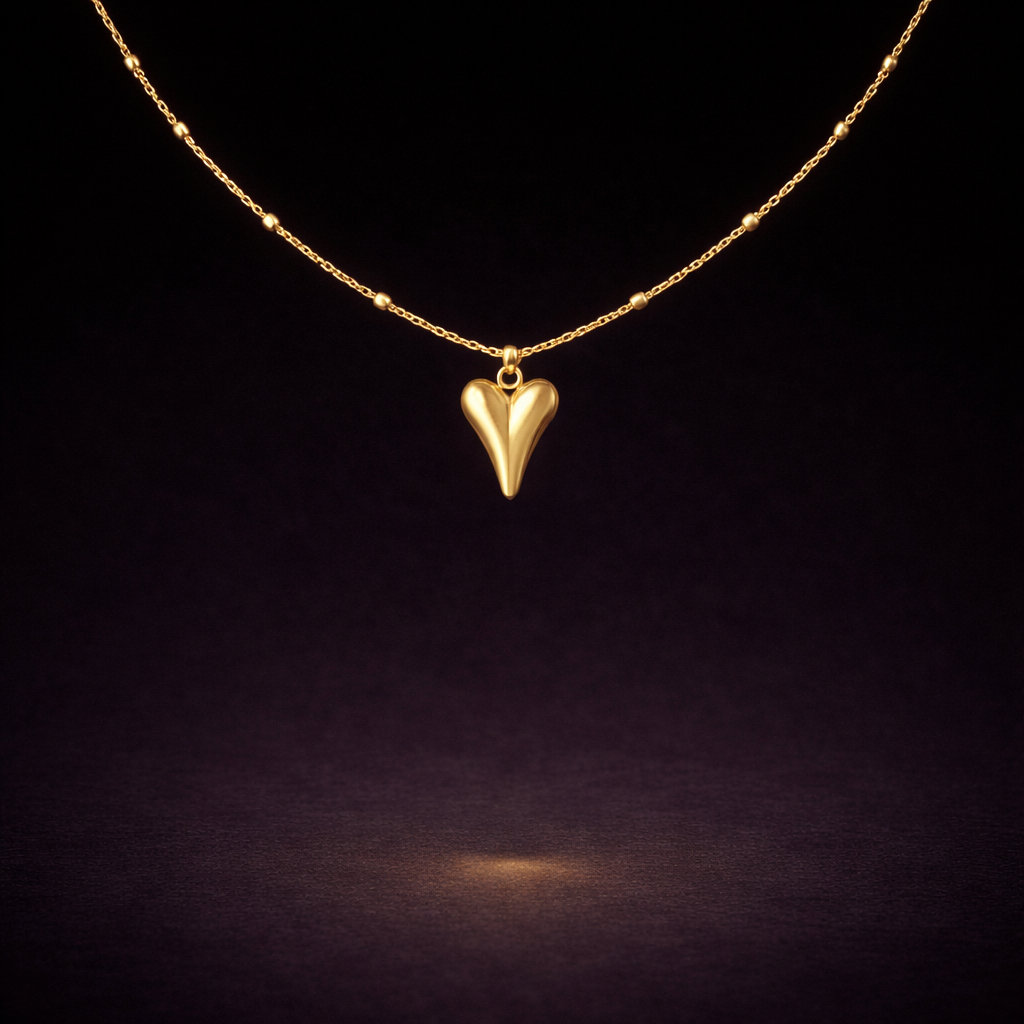 Minimal gold necklace with elongated heart pendant and delicate beaded chain