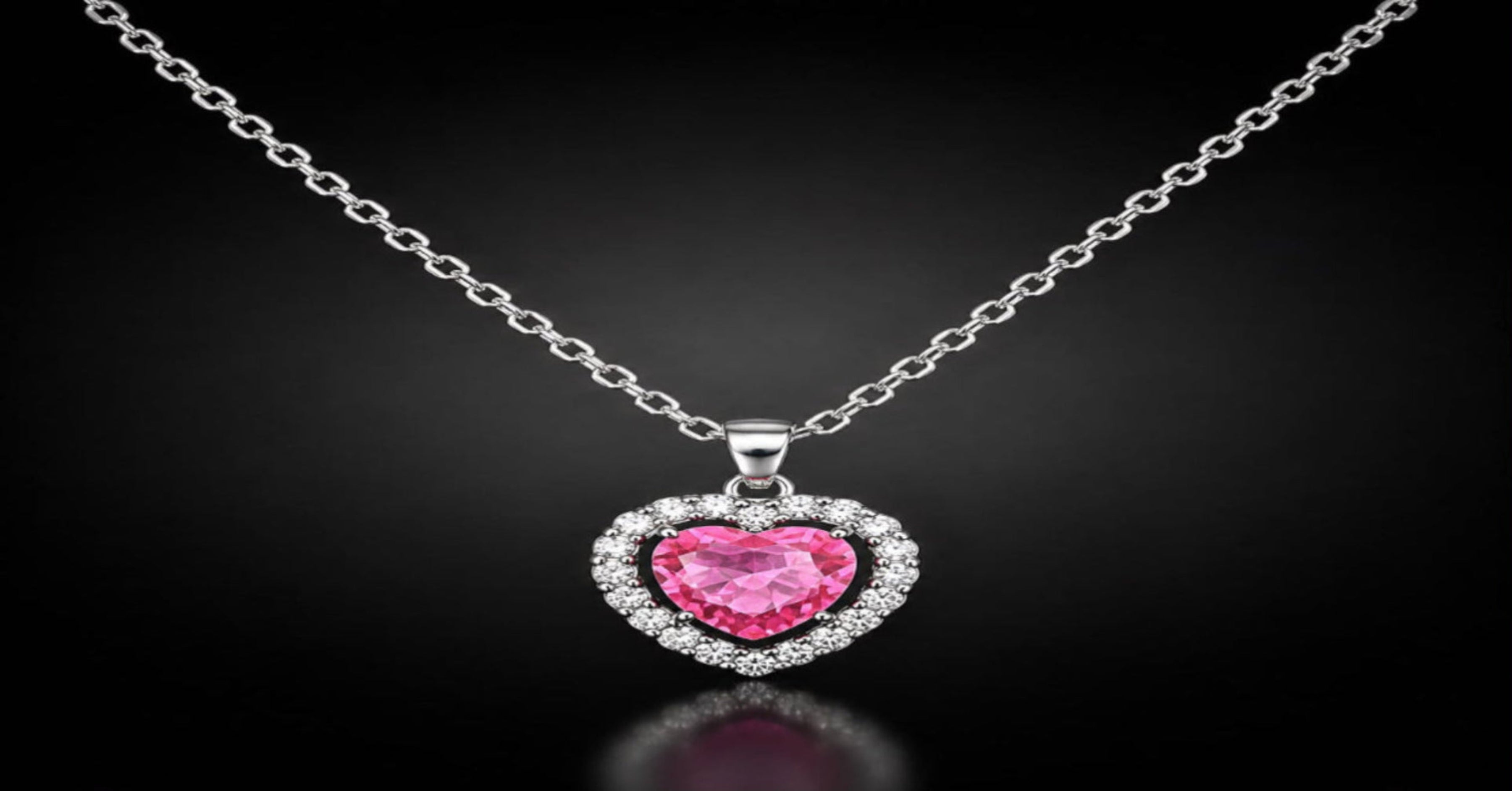 Aura Amore heart halo necklace featuring a pink crystal heart pendant surrounded by sparkling stones on a silver chain.