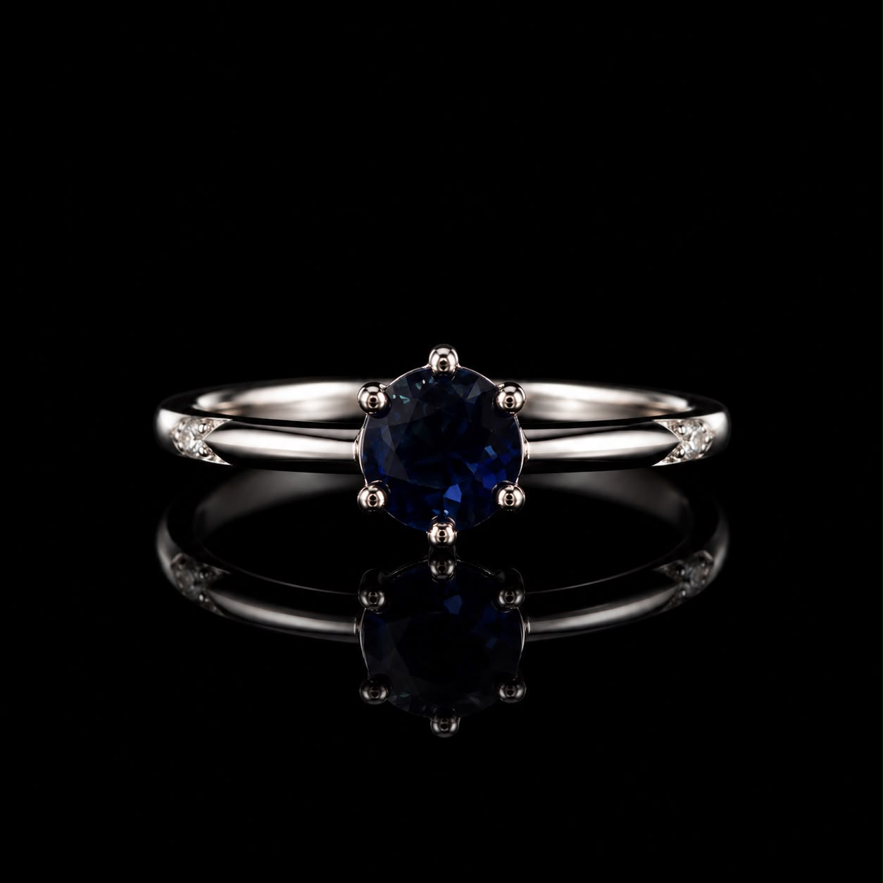Aura Midnight Sapphire Ring featuring a deep-blue round crystal solitaire set on a polished silver-tone band with sparkling accent stones.