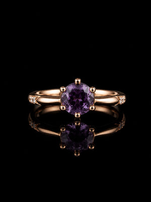Aura Amethyst Rose Ring featuring a sparkling purple crystal solitaire set on a polished rose gold-tone band with delicate accent stones.