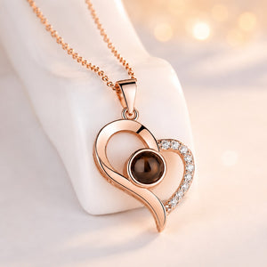 Aura Eternal Love Projection Necklace in rose gold featuring an elegant heart pendant with sparkling zircon crystals and a hidden nano projection stone displaying “I Love You” in 100 languages.